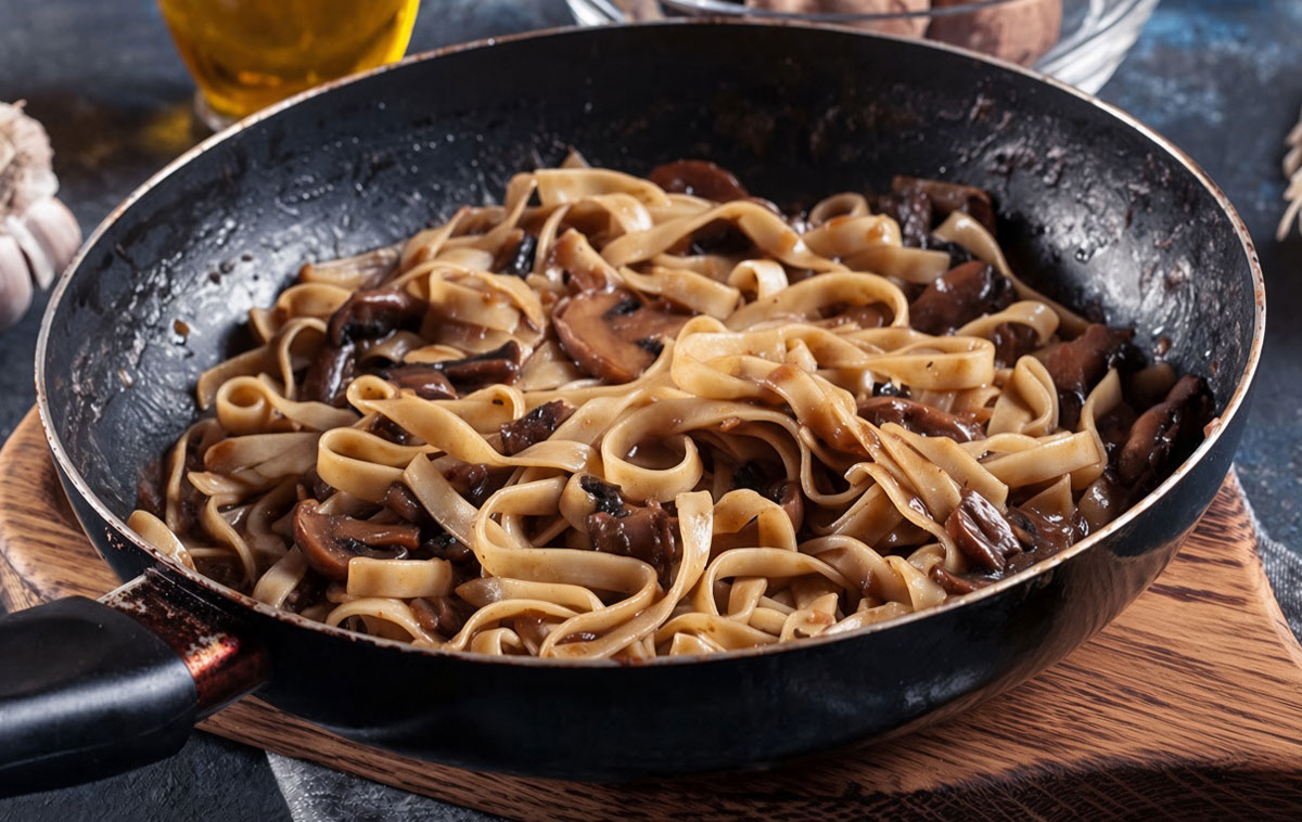 Una padella di tagliatelle e funghi